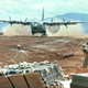 An Air Force C-130 performs a low altitude parachute extraction system (LAPES) delivery of supplies to an airbase in Vietnam (US Air Force)